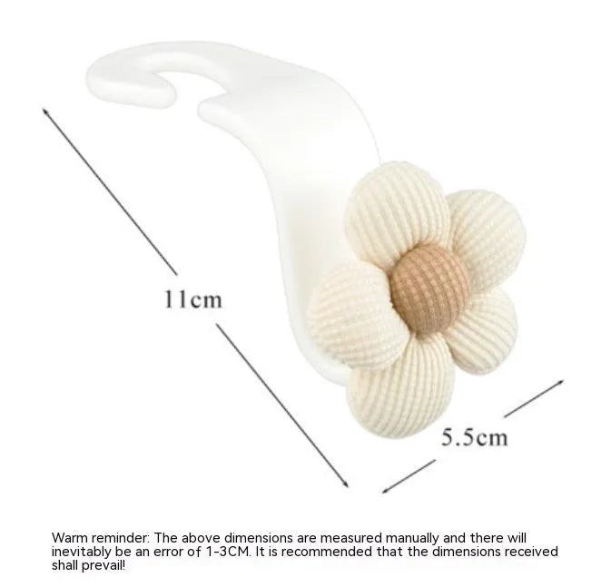 Plastic car seat hook in white, 11 by 5.5 cm, hanging from a headrest