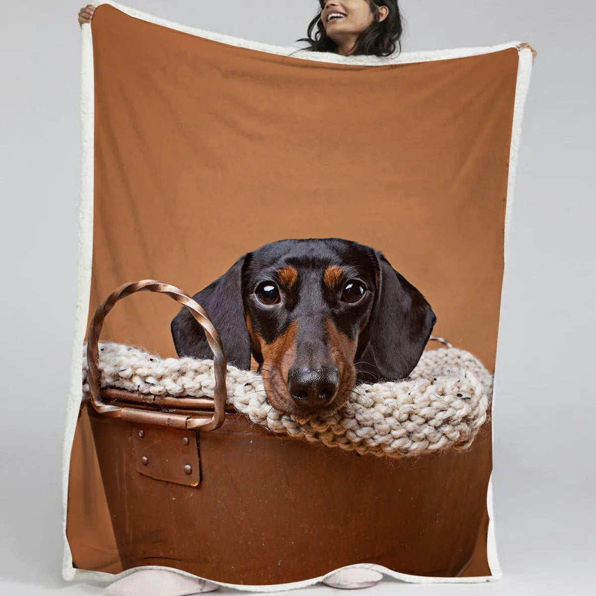 Brown sausage dog themed lamb wool blanket folded on a sofa, 130x150cm size