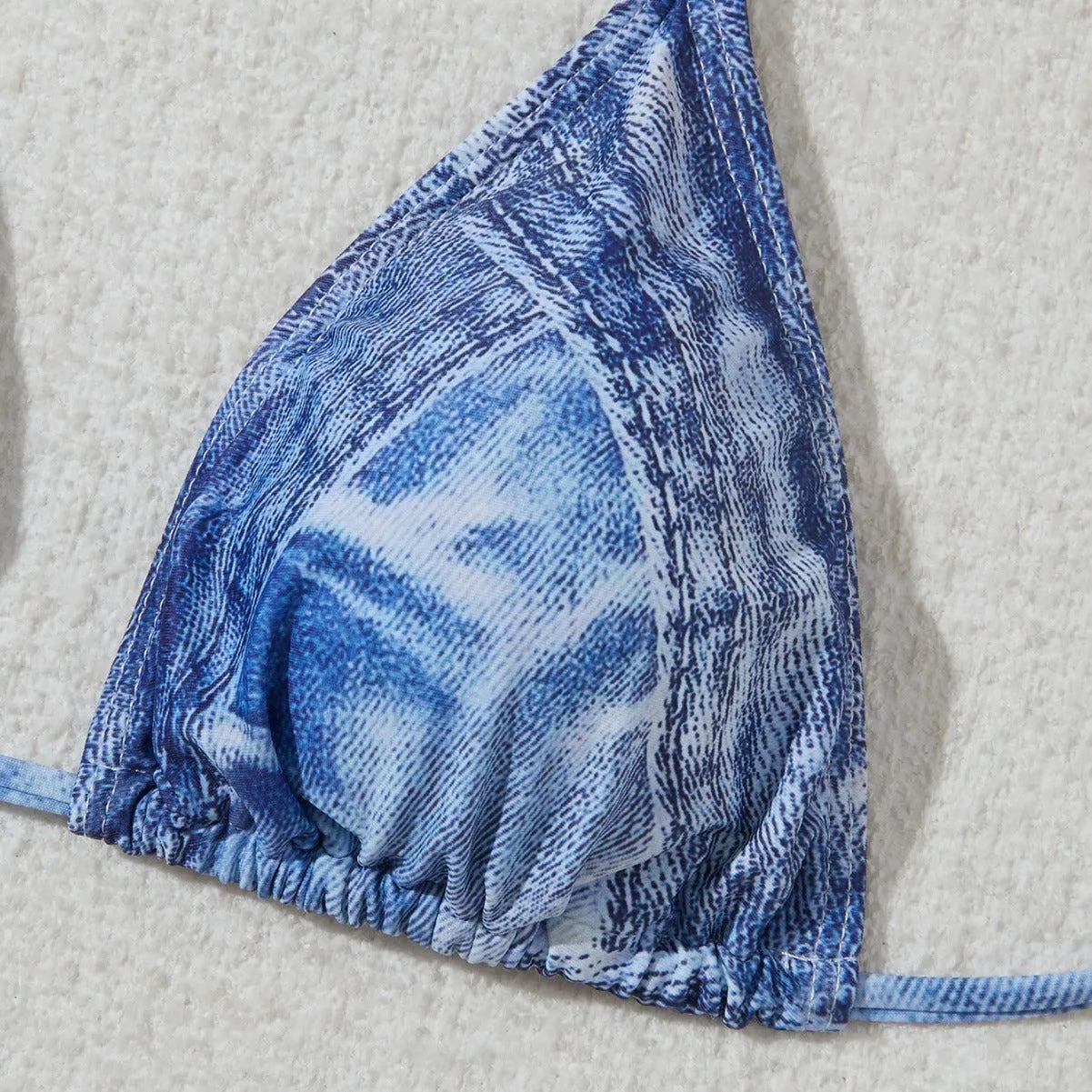 Denim blue printed women's bikini set with strappy triangle top and matching bottoms on a neutral background.