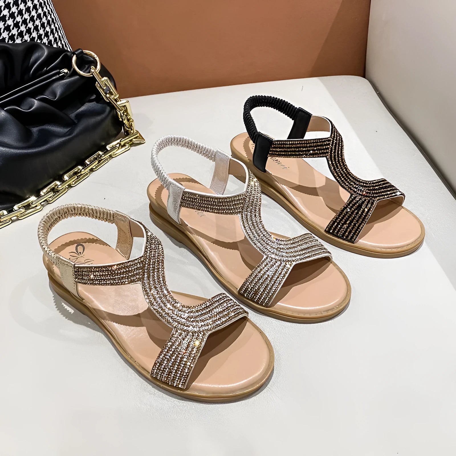 Women's gold patent leather beach sandals with rhinestone decoration on a rounded toe strap.