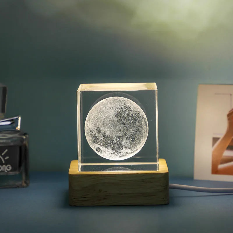 3D transparent crystal cube night lamp with warm light pattern on wooden desktop