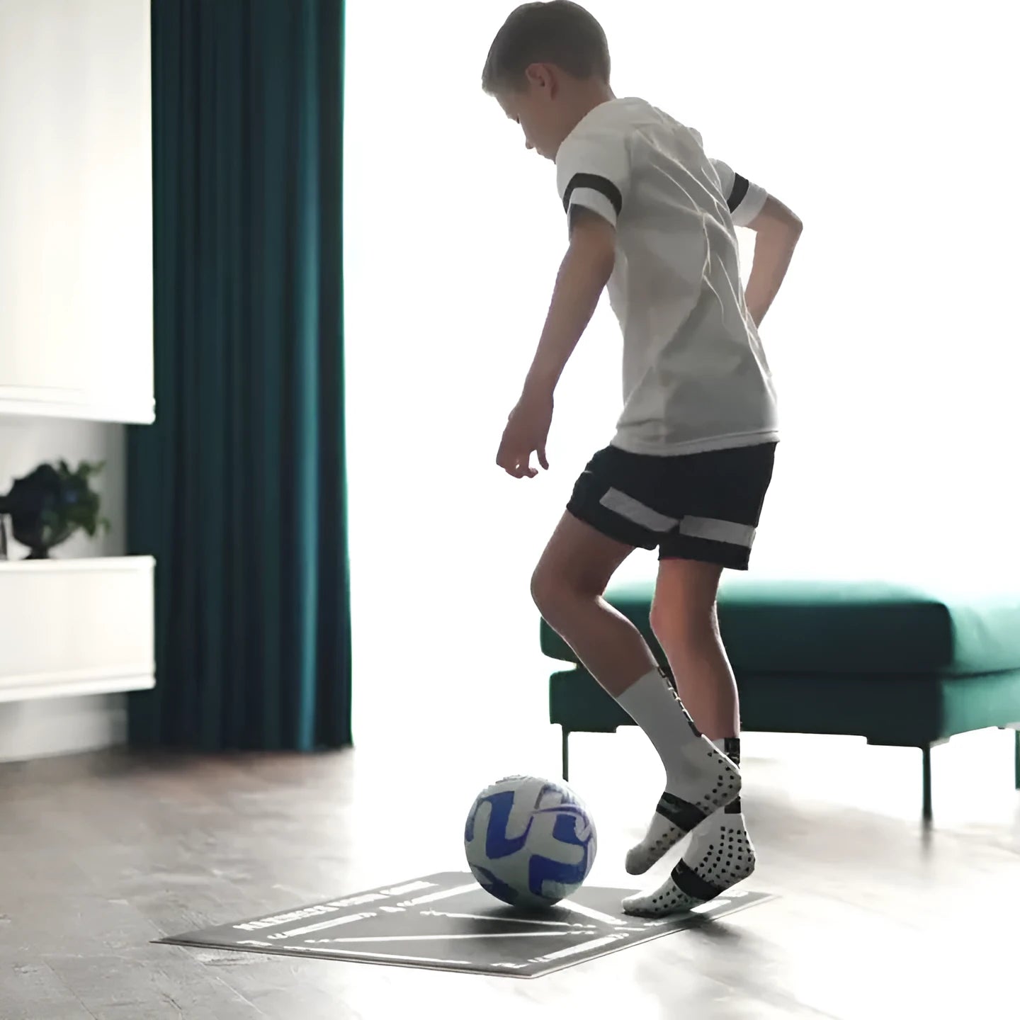 Black football training mat measuring 60x90cm on a flat surface