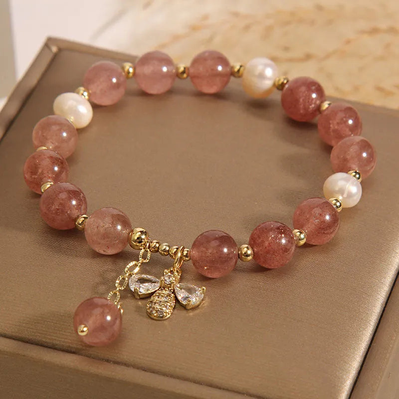 Women's beaded bracelet with strawberry quartz stones, freshwater pearls, and zircon accents on alloy.