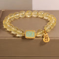 Women's natural yellow crystal bracelet with citrine colour round beads and rhinestone accents, sliding knot closure