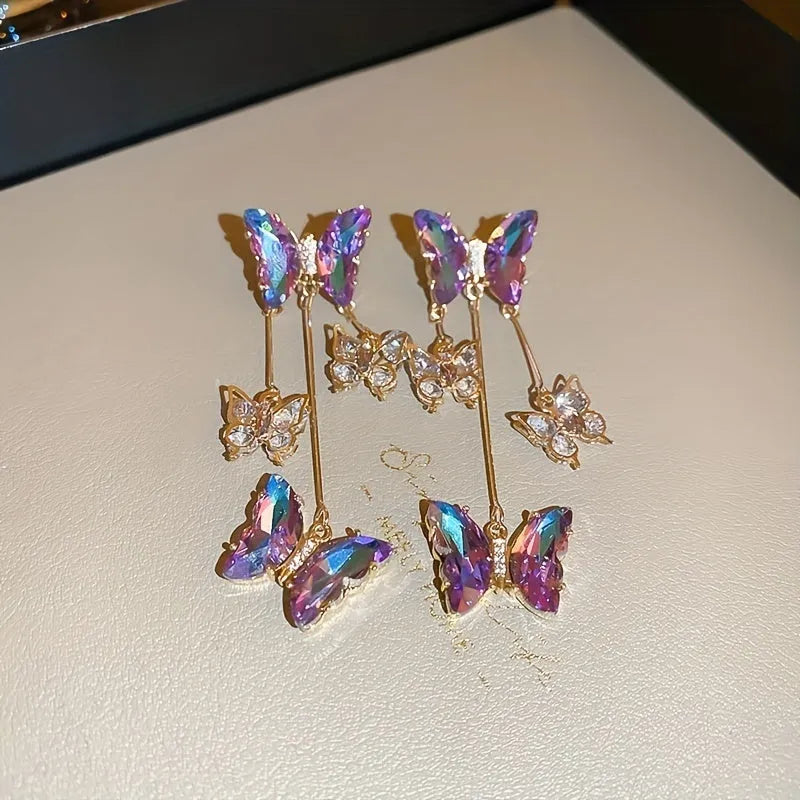 Close-up of women's silver needle blue purple butterfly tassel earrings with crystal flowers on alloy.