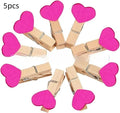 Five solid wood heart-shaped clips in red colour arranged together
