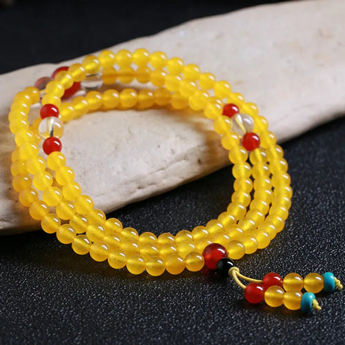 108-bead polished agate and crystal necklace with geometric beads and matching canary stone bracelet on display