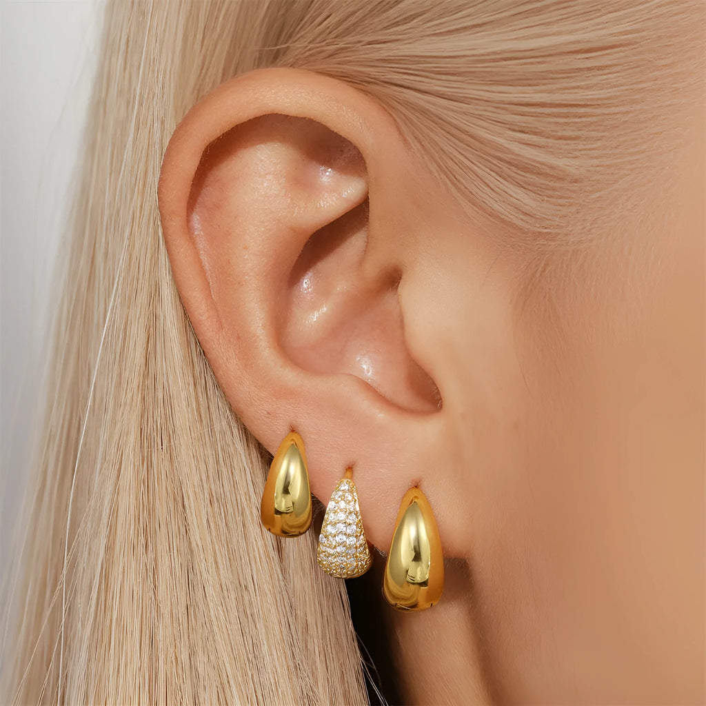 A pair of round, geometric brass earclip earrings with a gold electroplated finish.