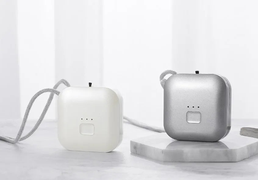 Mini USB rechargeable wearable air purifier necklace in pink, showing compact dimensions.