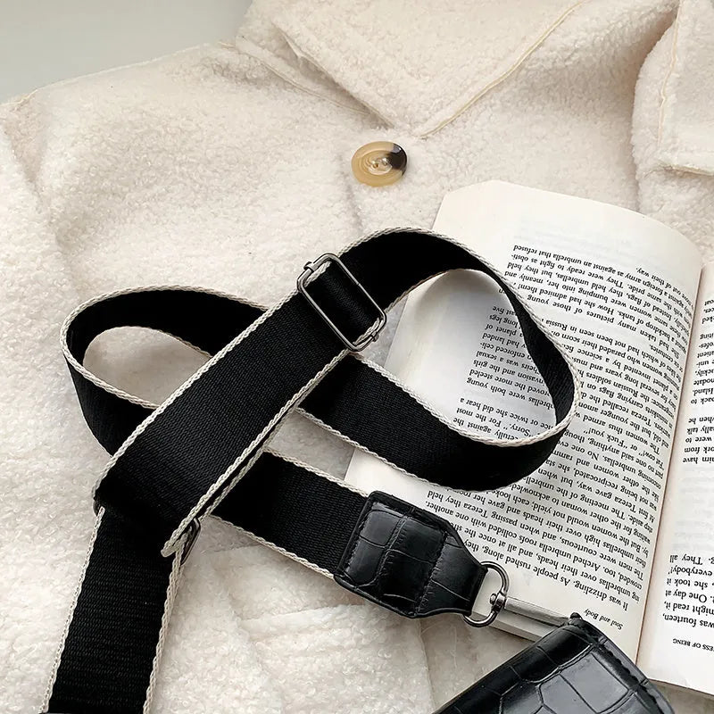 Vintage-style women's crossbody bag in PU leather, shown in black, with adjustable strap.