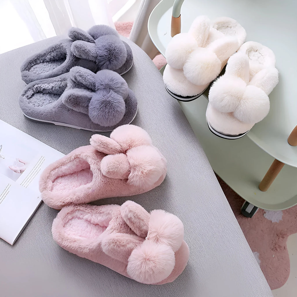 Women's fluffy rabbit fur high upper winter slippers in grey on a wooden floor.