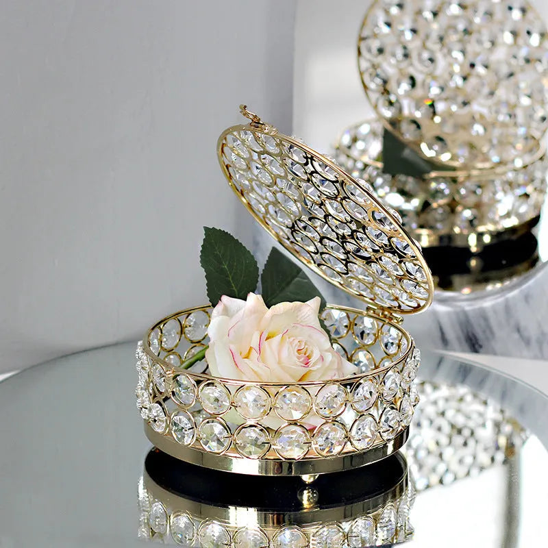 Clear crystal glass jewellery box with a French gold metal frame on a table.
