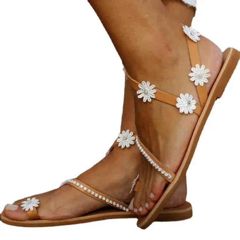Brown women's beach sandals with floral pattern, flat rubber sole, and herringbone toe design