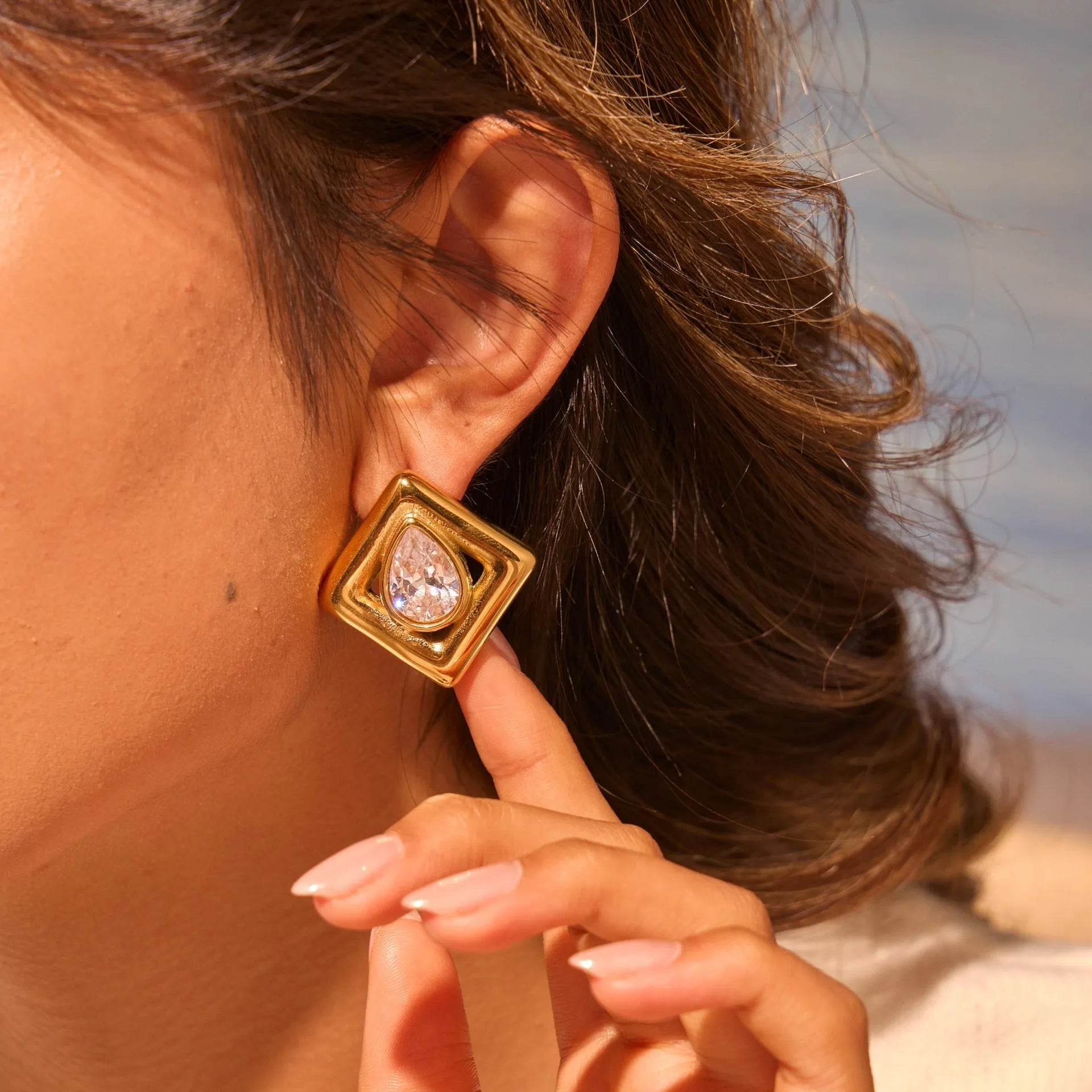 Gold-coloured geometric stud earrings with inlaid water drop zircon stones