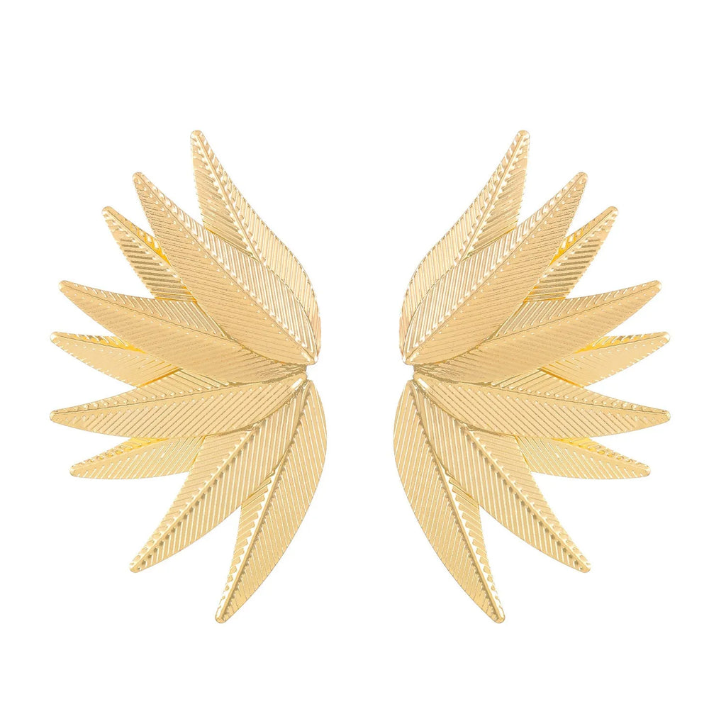 Gold and white leaf-shaped patch earrings made of alloy metal on a neutral background