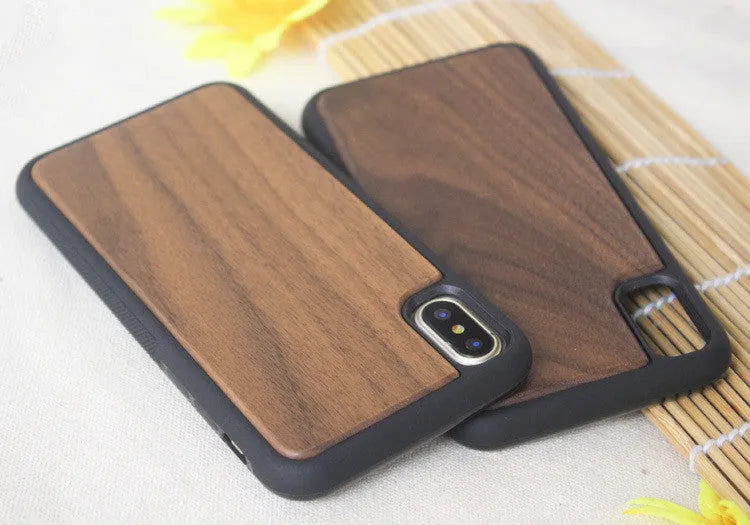 Wooden iPhone case with carbonised bamboo back and black TPU edges on a table.