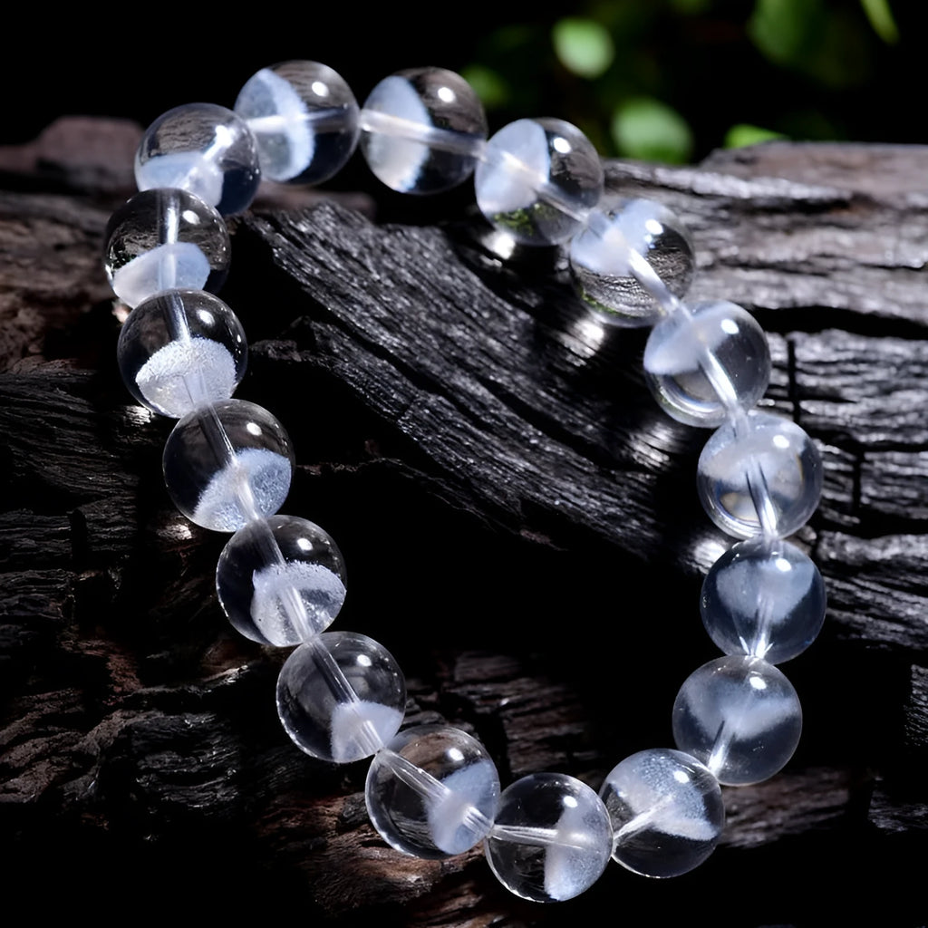 Close-up of a women's white crystal ghost pyramid bracelet with a Ruyi charm on a wrist.
