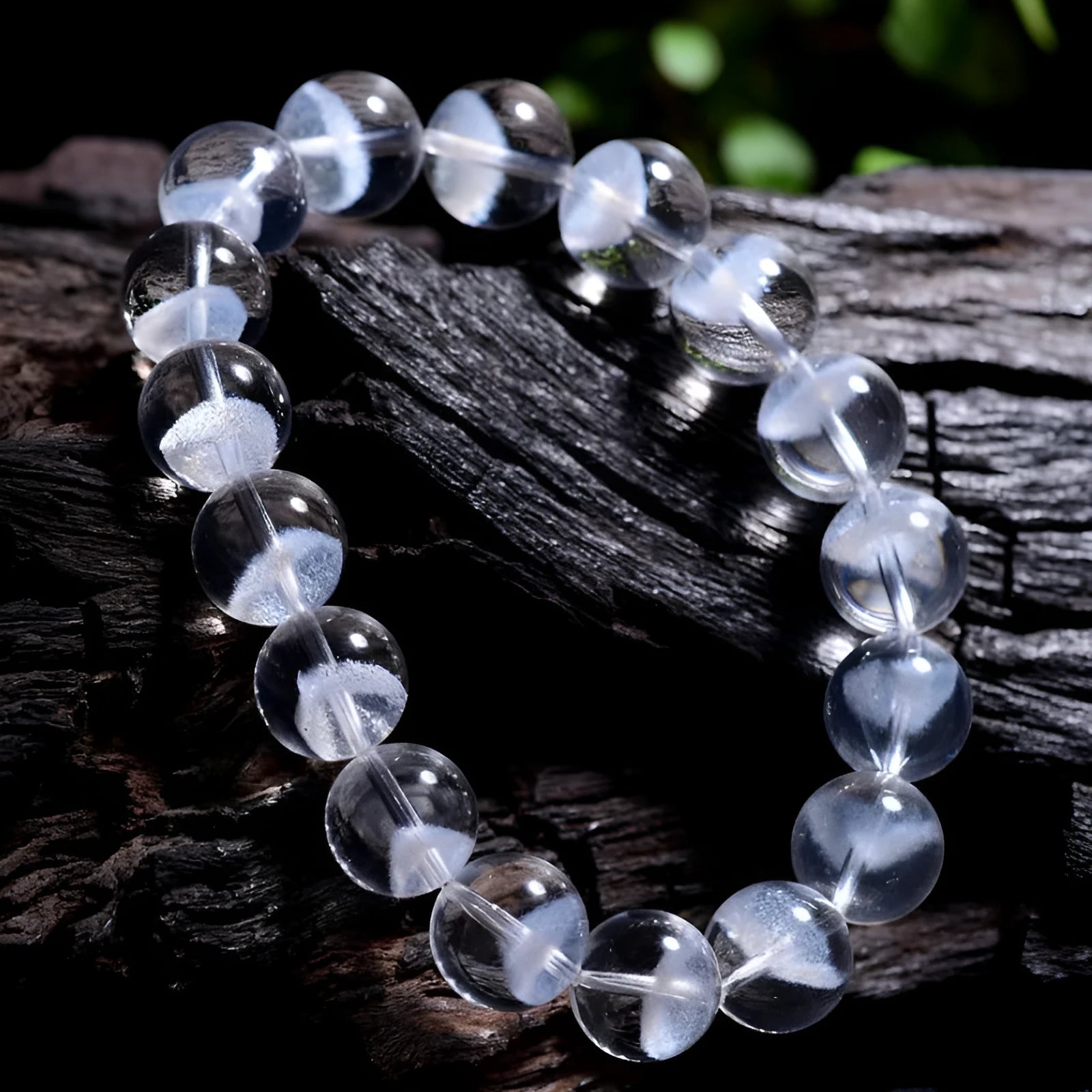 Close-up of a women's white crystal ghost pyramid bracelet with a Ruyi charm on a wrist.
