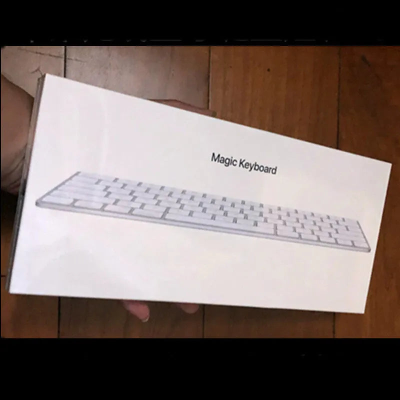 Apple ultra-thin metal Bluetooth wireless keyboard in white on a desk.