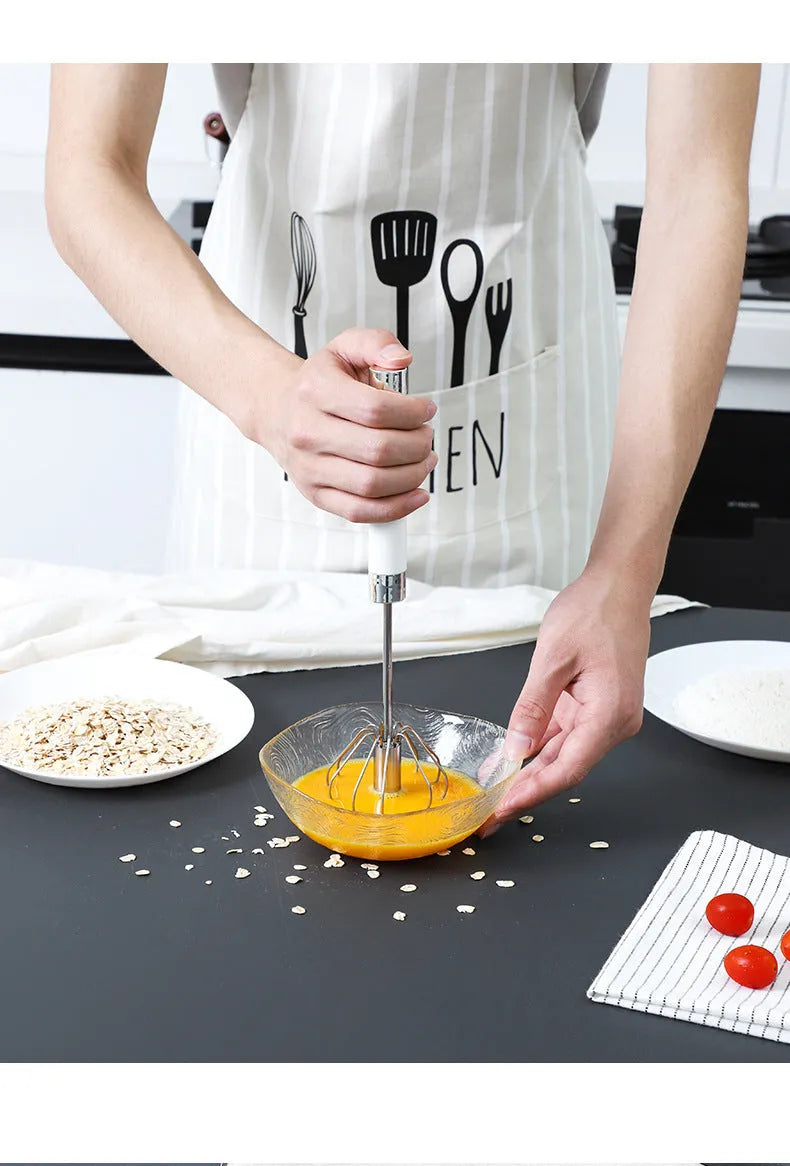 Semi-automatic stainless steel egg beater whisk with hand pressure rotating handle, silvery colour, on white background
