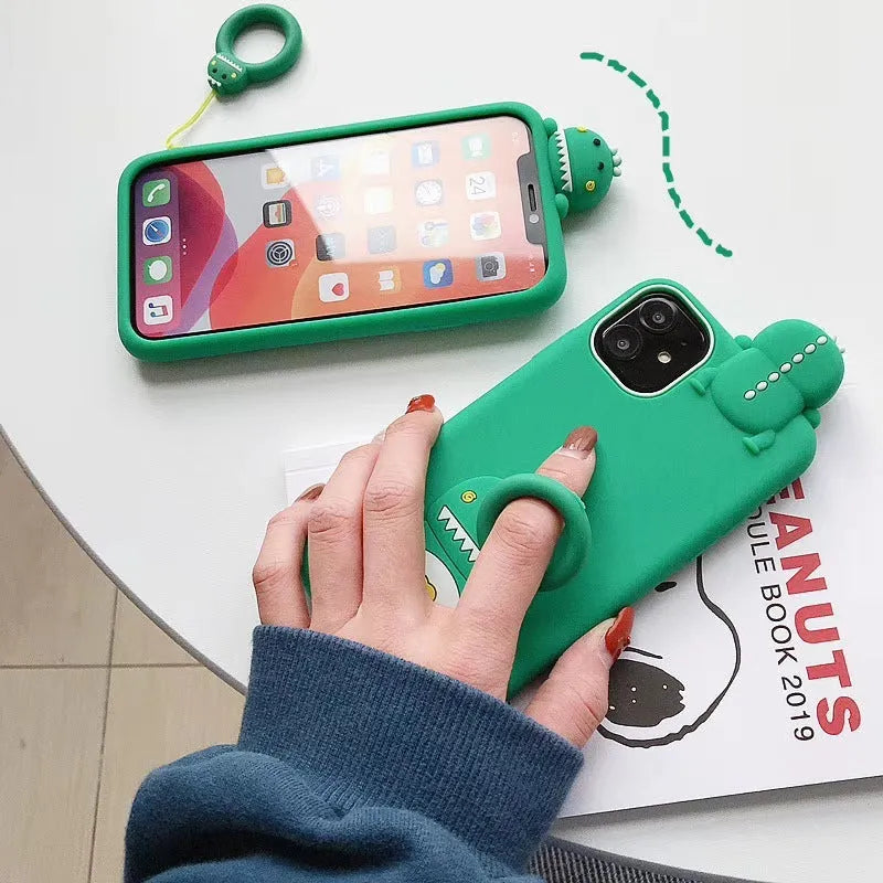 Green silicone iPhone case with a cartoon animal design on a table.