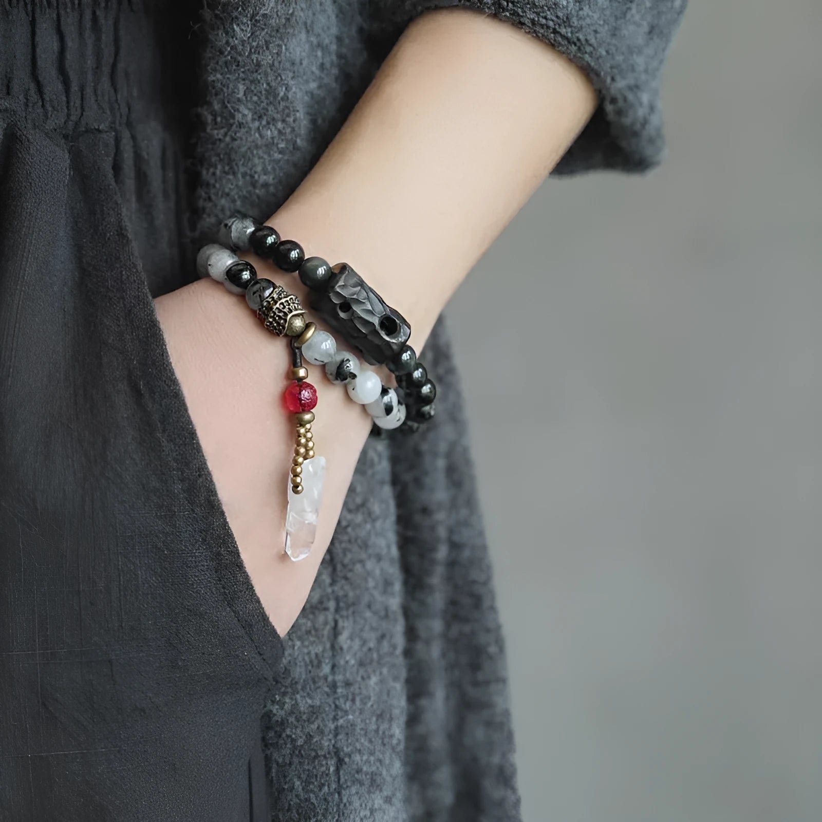Ethnic style black hair crystal bracelet with white crystal tassel and bending lacing closure on plain background
