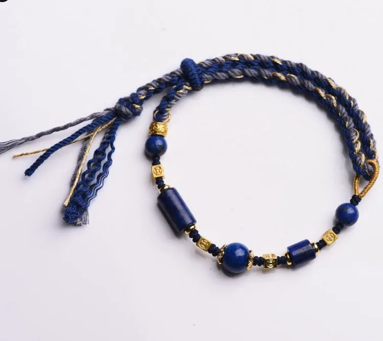 Hand-woven lapis lazuli flexible wire bracelet with simple ethnic design on white background