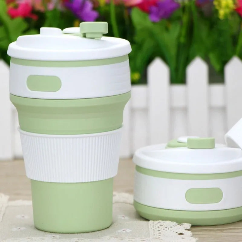 Collapsible silicone travel cup in grey, folded to 6 cm height, with anti-hot handle and leak-proof cover