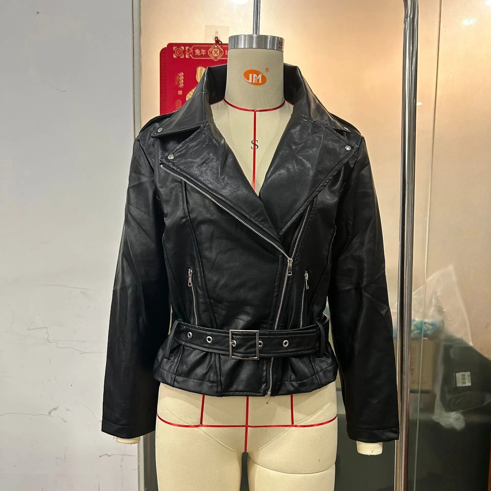 Black punk style leather jacket with a Peter Pan collar and drawstring waist on a hanger.