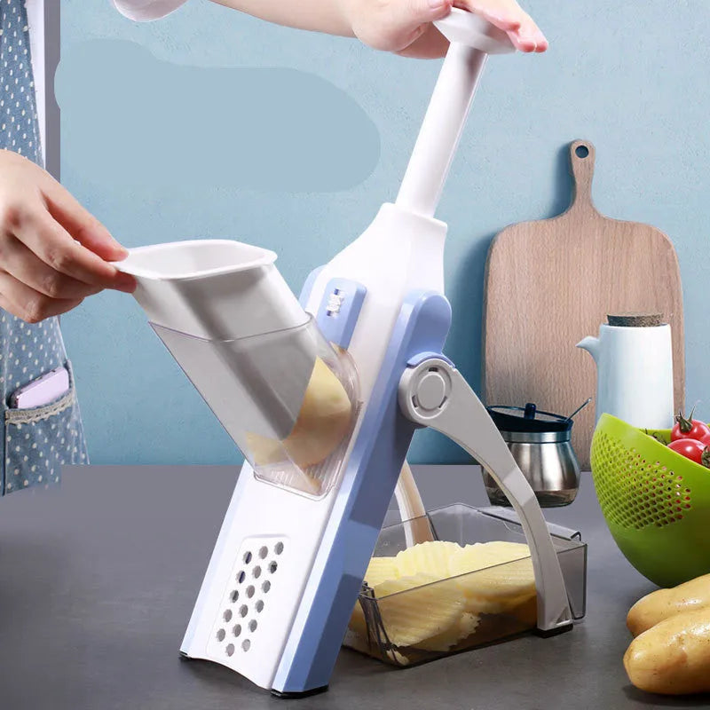 White and blue multifunctional vegetable slicer with stainless steel blade and cleaning brush on a kitchen counter