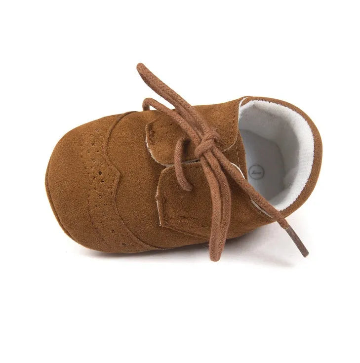 Vintage style soft-soled baby walking shoes in synthetic leather, shown in light brown colour.