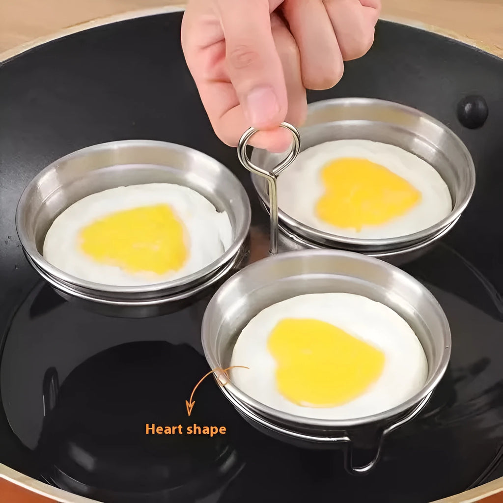 Small stainless steel heart-shaped egg steamer or round egg cooker for use on a hob.