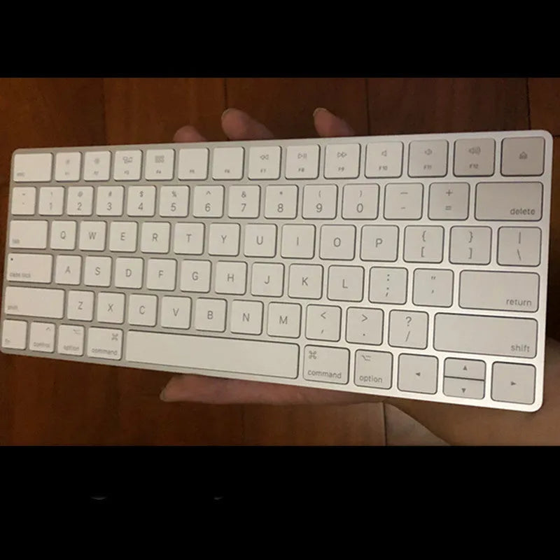 Apple ultra-thin metal Bluetooth wireless keyboard in white on a desk.