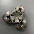 Alloy decompression fingertip gyro toy in gun colour finish on a dark background