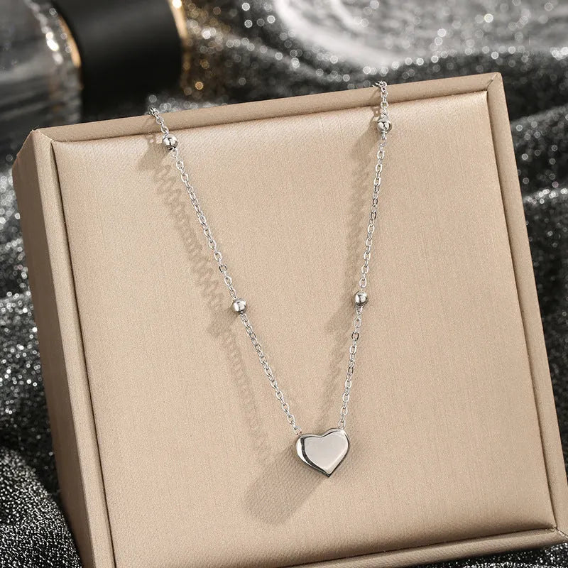 Women's titanium steel necklace with geometric pendant and ball bead chain in silver finish on white background