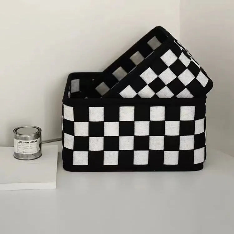 Black and white checkerboard woven felt storage basket with folded sides.