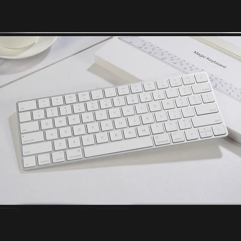 Apple ultra-thin metal Bluetooth wireless keyboard in white on a desk.