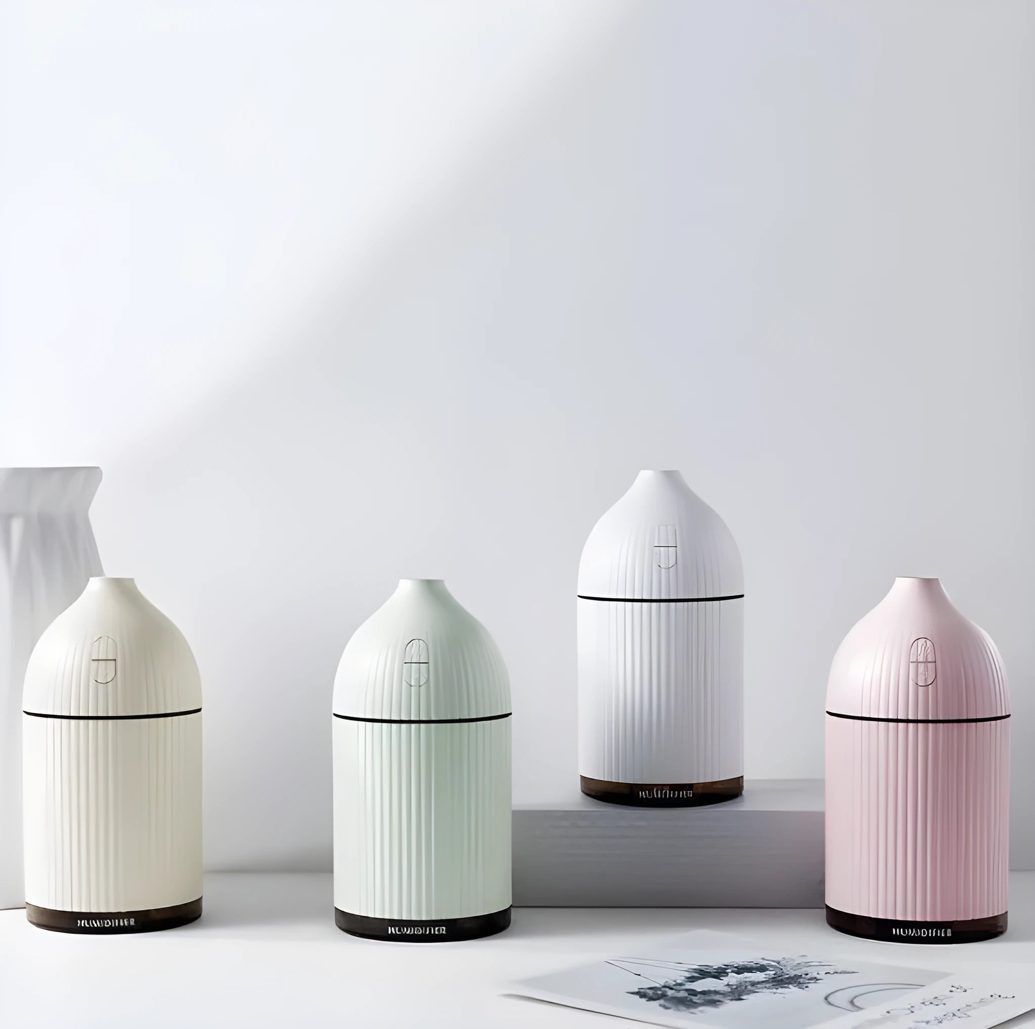 White ultrasonic aromatherapy diffuser with LED lights showing water mist emission