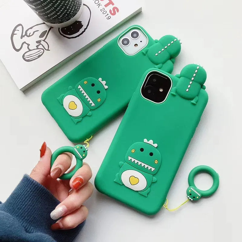 Green silicone iPhone case with a cartoon animal design on a table.