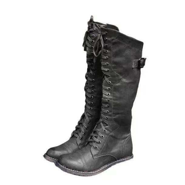 Women's black chunky heel high leg boot with round toe and low stout heel on a solid background.