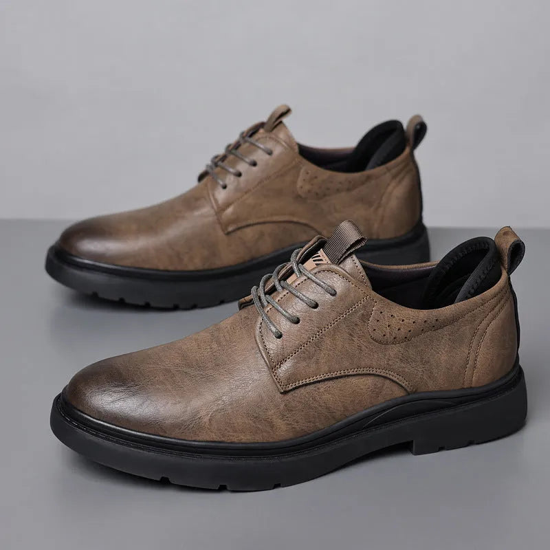 Men's black and brown leather shoes with rubber sole and sewn detailing on a white background.