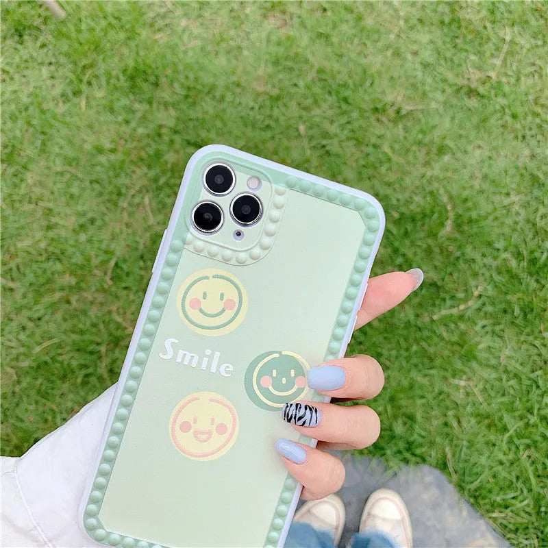 Green TPU iPhone back cover case with geometric smiley face and polka dot design.