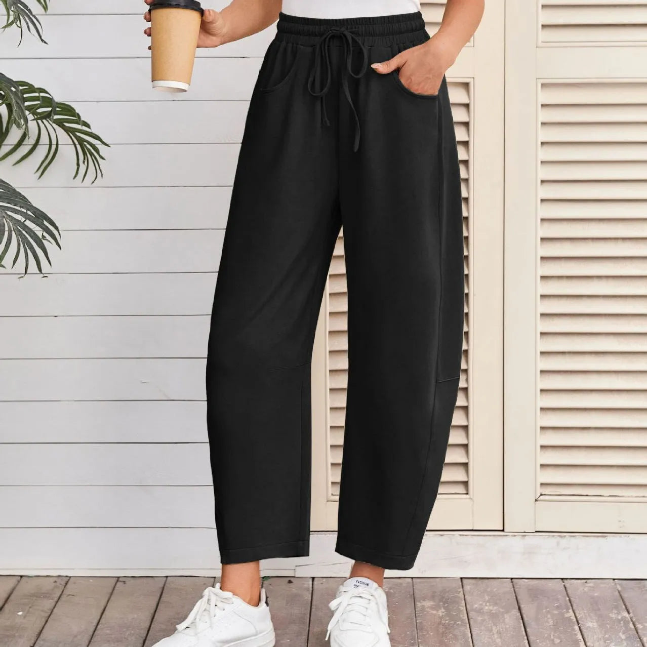 Loose cropped sweatpants with elastic drawstring waist and pockets in street fashion styling