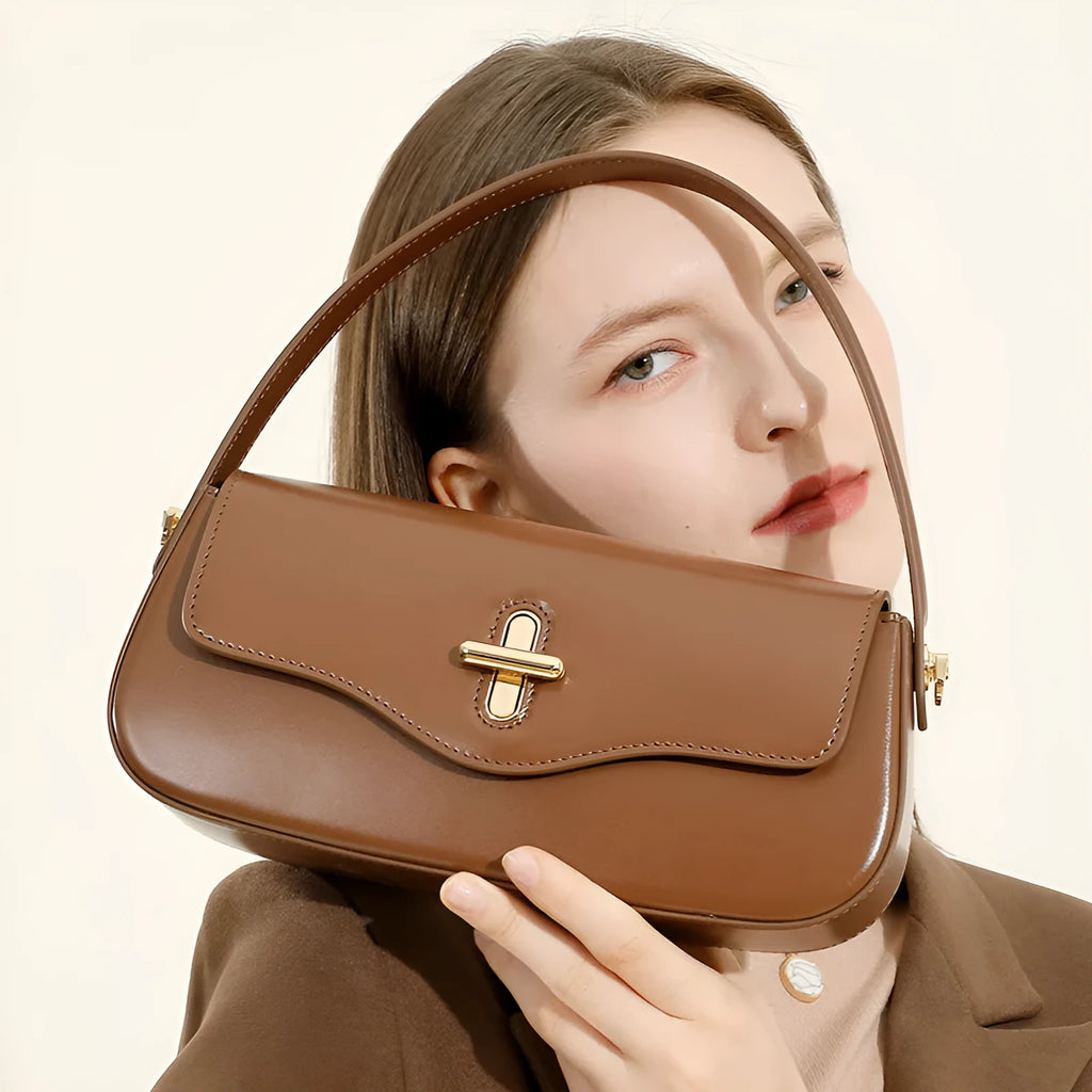 Genuine leather baguette handbag in black with clamshell opening and lock detail