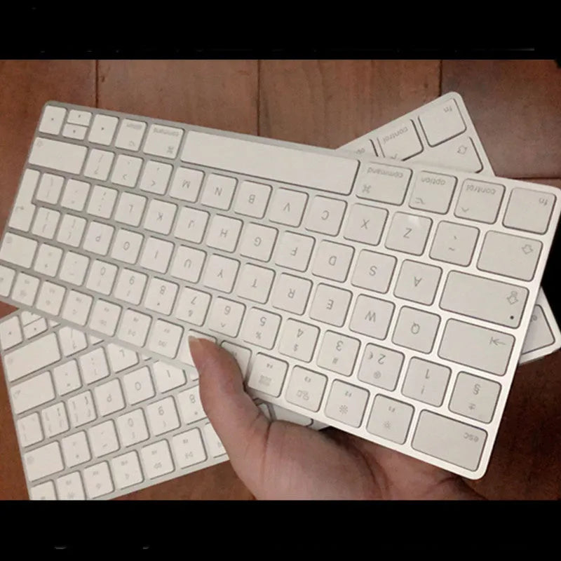 Apple ultra-thin metal Bluetooth wireless keyboard in white on a desk.