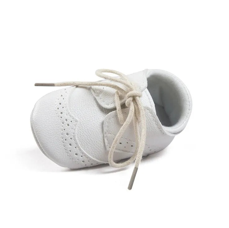 Vintage style soft-soled baby walking shoes in synthetic leather, shown in light brown colour.