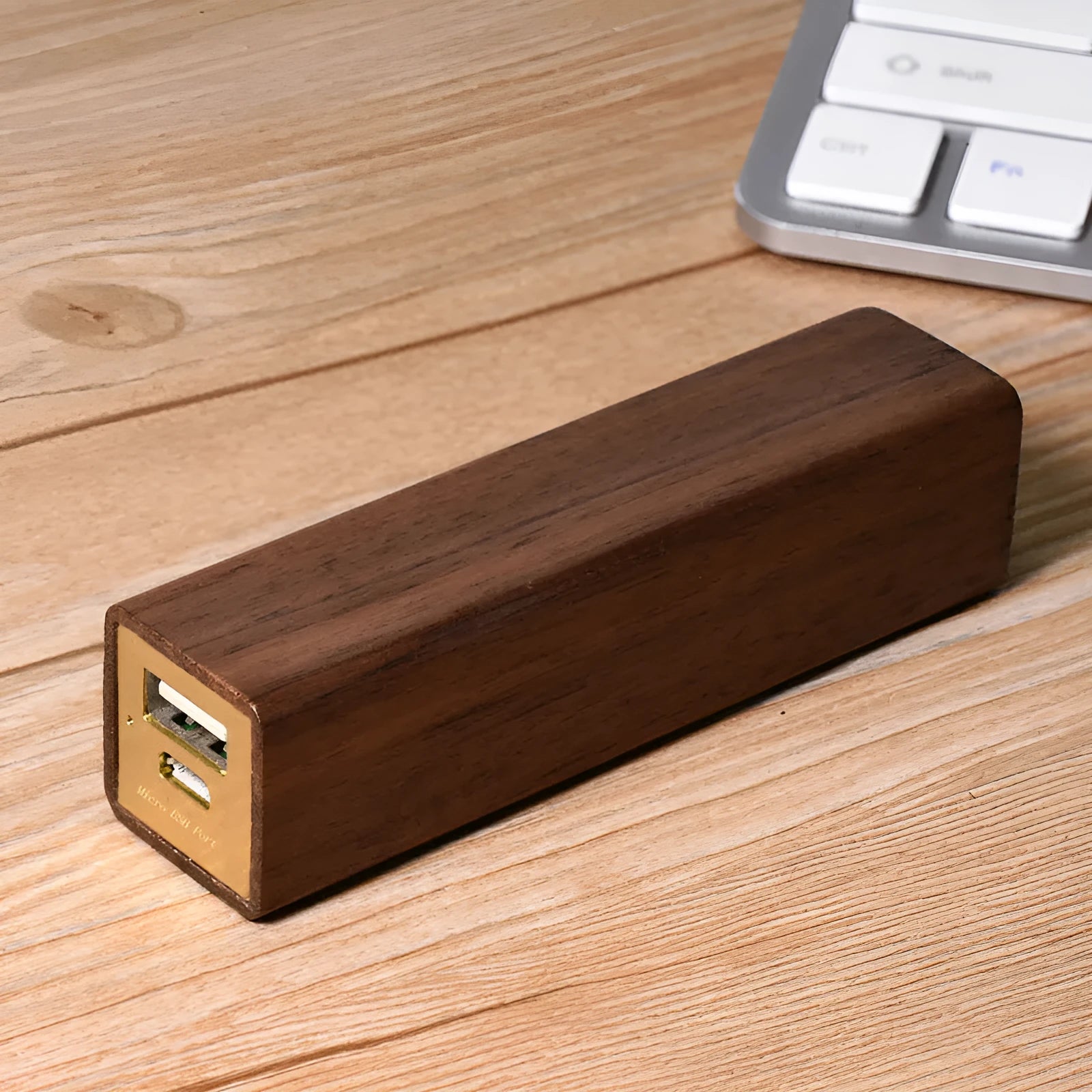 Portable power bank with brown walnut wood shell and USB port on a light background