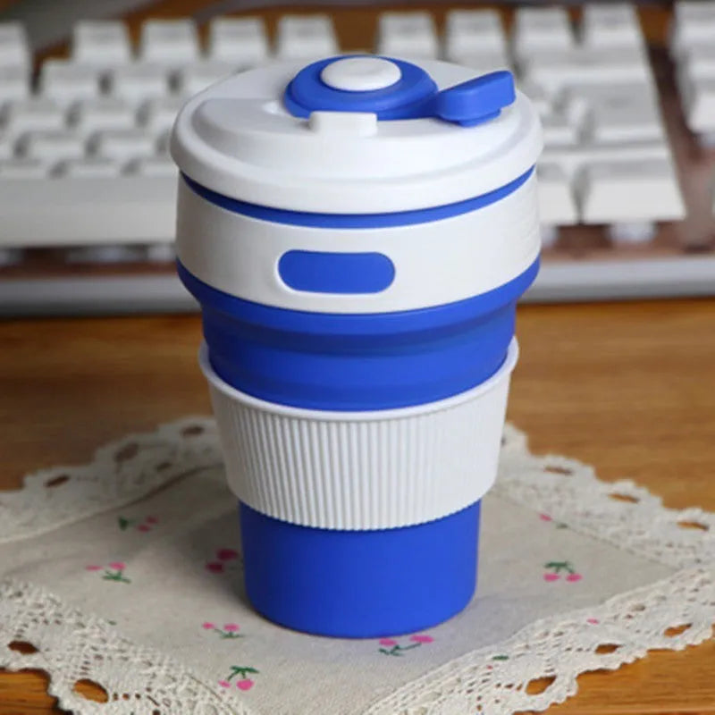 Collapsible silicone travel cup in grey, folded to 6 cm height, with anti-hot handle and leak-proof cover