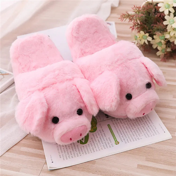 Pair of soft pink pig-shaped plush slippers with a cute animal face design.