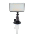 Black aluminium alloy portable LED ring light for laptop video conferencing on a desk.
